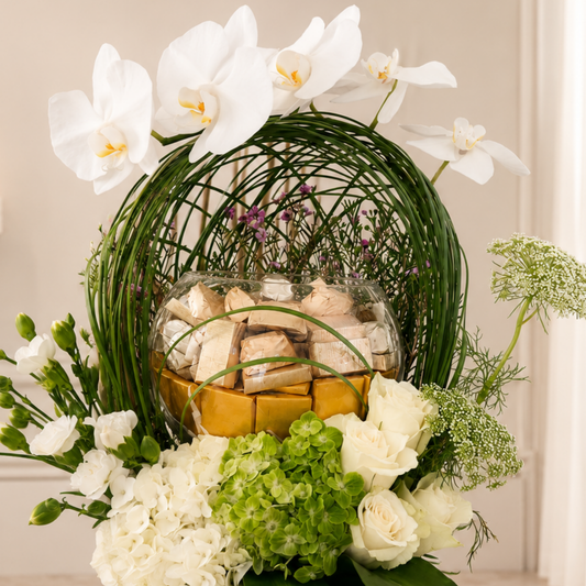 Luxury white Phalaenopsis arrangement with chocolates in a black designer vase. online flowers arrangement delivery all over UAE