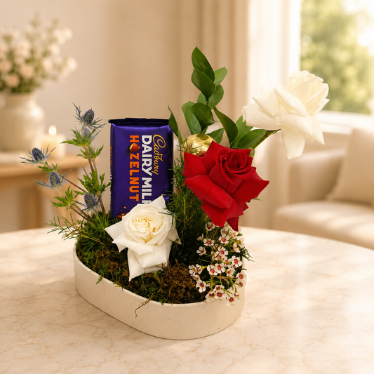Floral arrangement with a red rose, white flowers, and a chocolate bar. Chocolate and Flowers arrangement