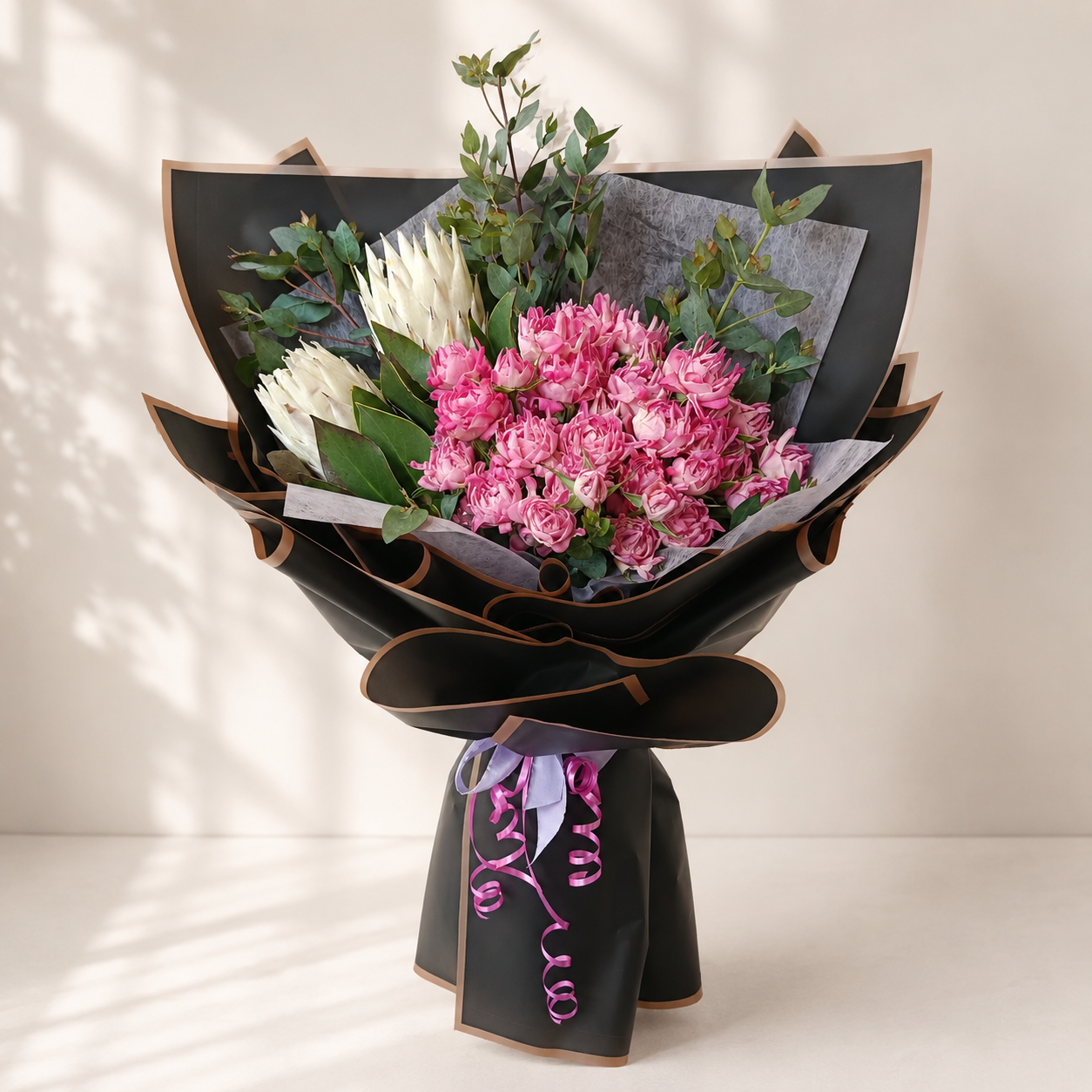 Bouquet of pink flowers wrapped in black paper, online flowers delivery Dubai.