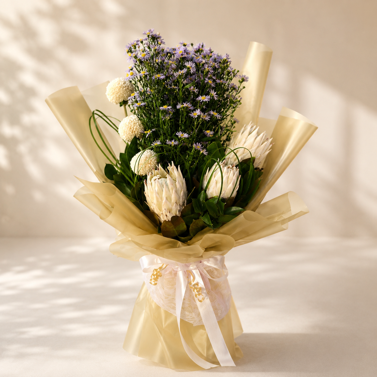 Bouquet of flowers wrapped in gold paper with a white ribbon, online flowers, delivery Dubai