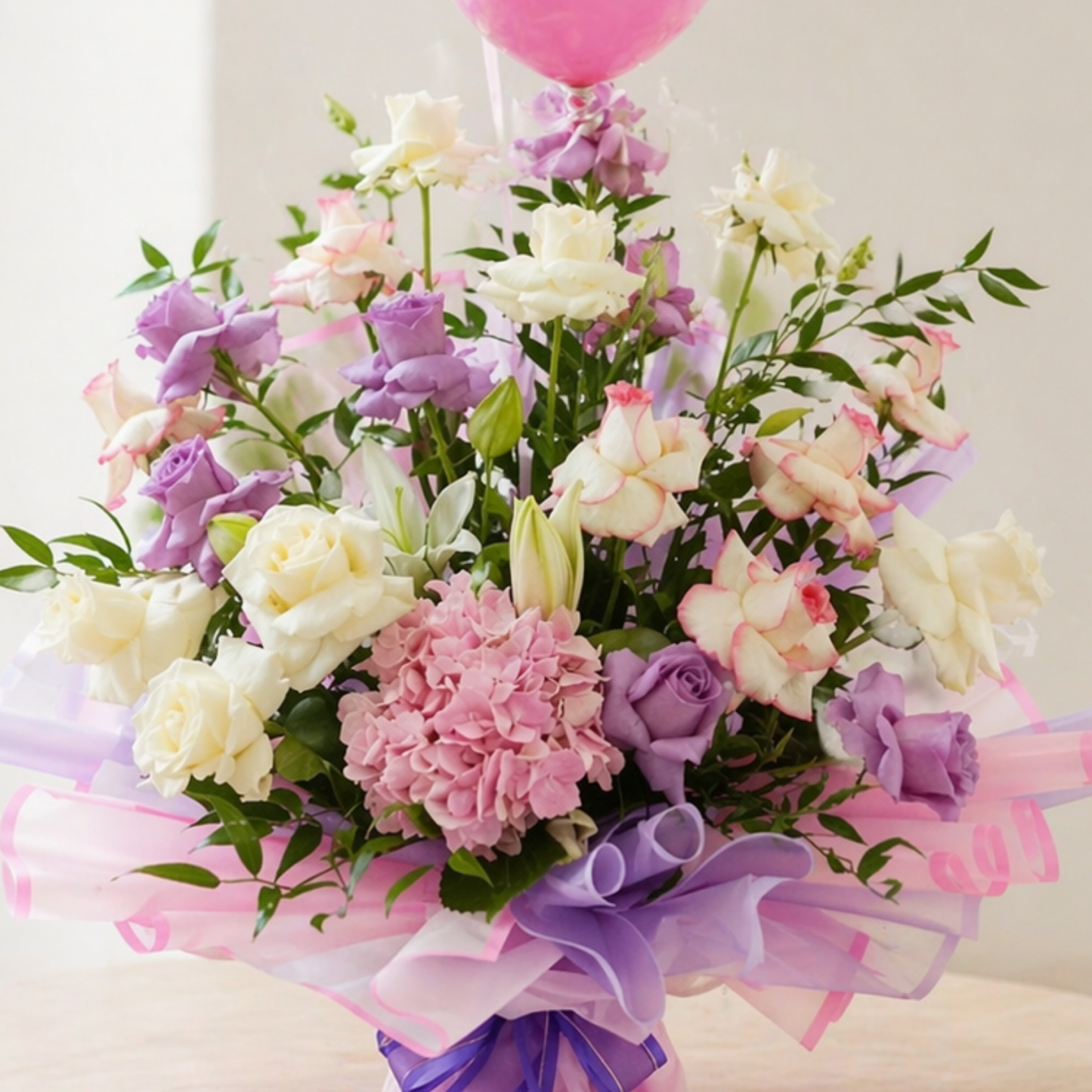 flower bouquet with pink and white roses, hydrangea, and balloons in elegant wrapping