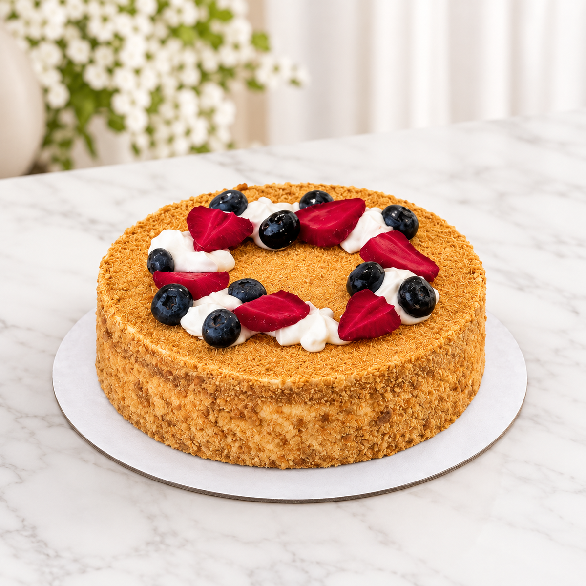 A round cake with a d with a ring of white whipped cream and fresh berries including blueberries and sliced red strawberries, for birthdays delivery across UAE.