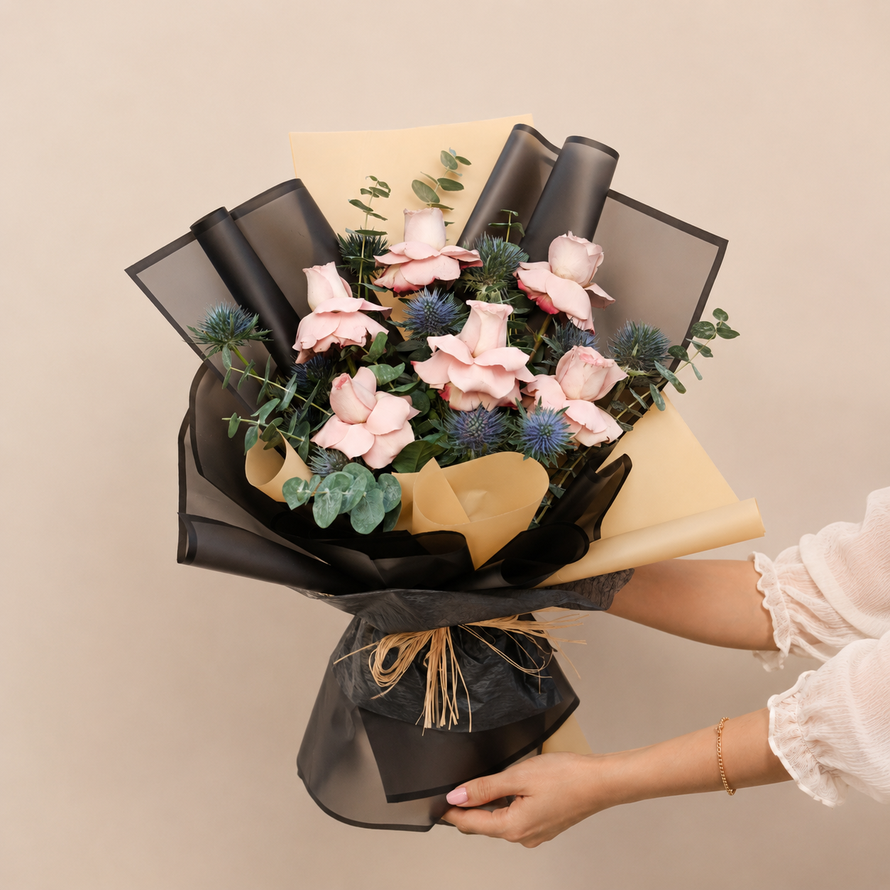 Luxury bouquet with nude roses, blue eryngium, eucalyptus, and premium black and beige wrapping. online flowers delivery Dubai