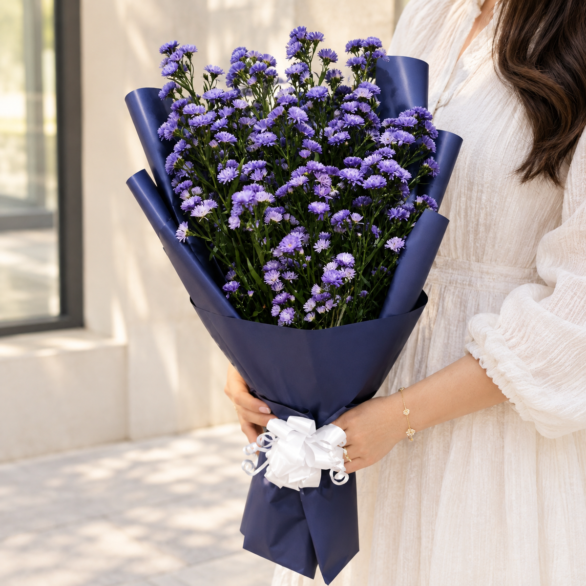 Purple aster flower bouquet with navy wrapping, delivery available all over UAE