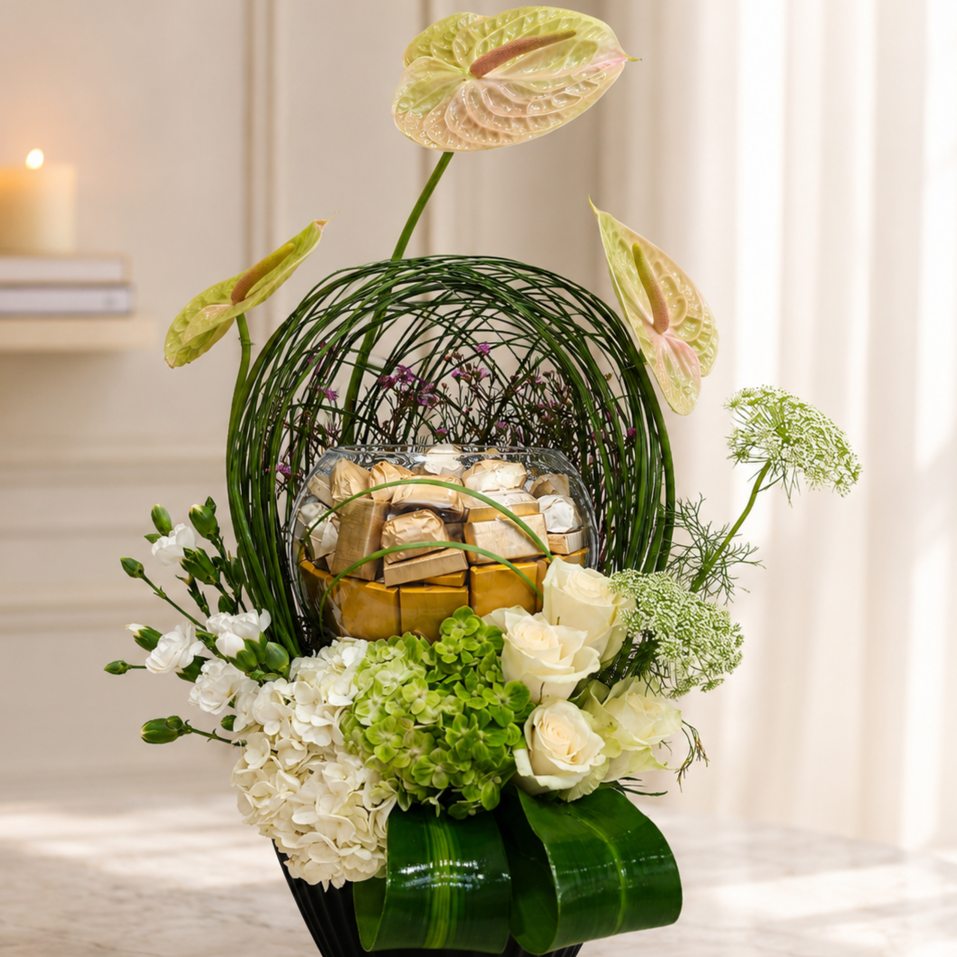 Luxury cream Anthurium floral arrangement with premium chocolates in a black designer vase. online flowers arrangement delivery Dubai.